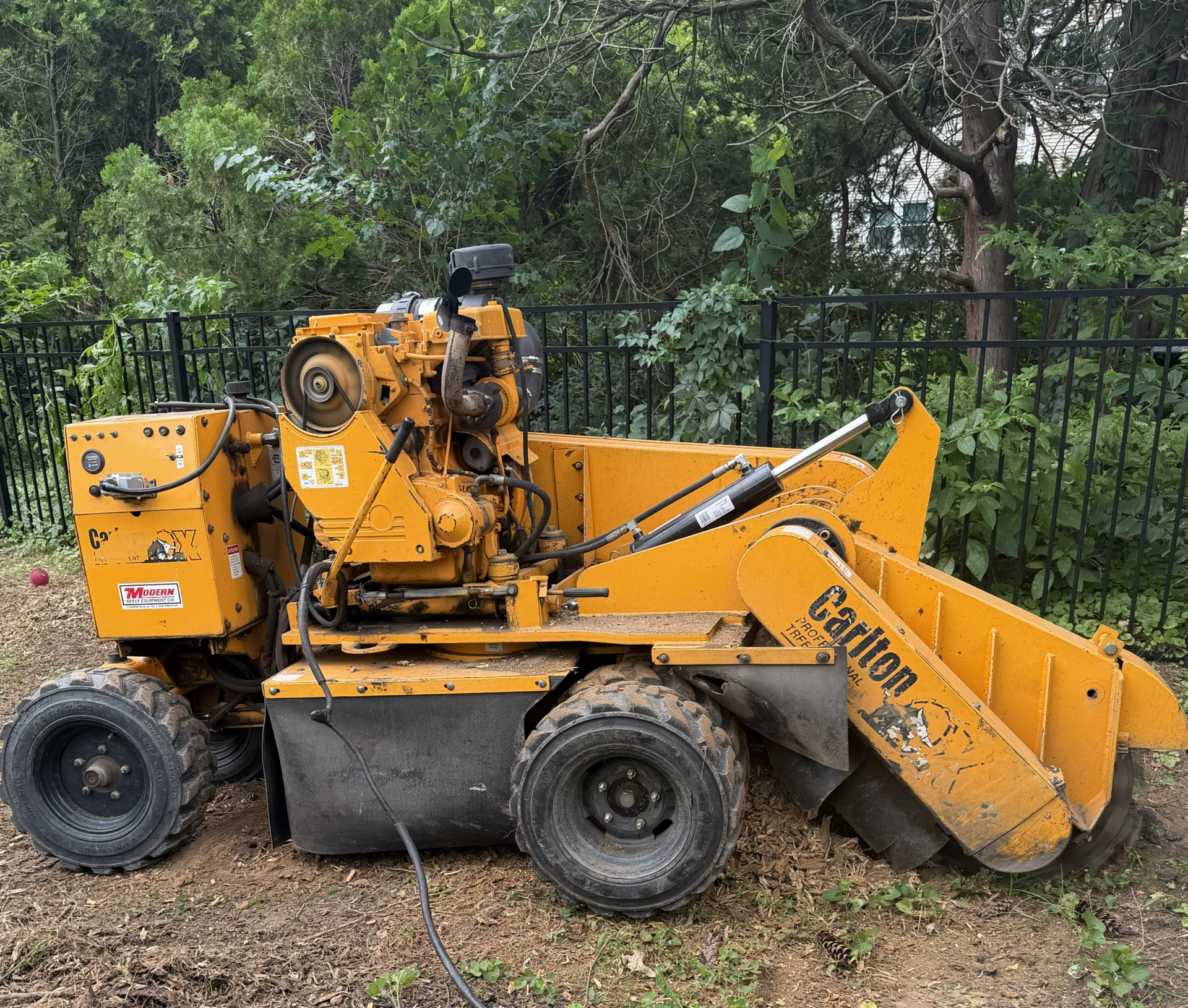 Carlton self-propelled stump grinder parked at a residential job site in the Timberwolf Tree Service coverage area